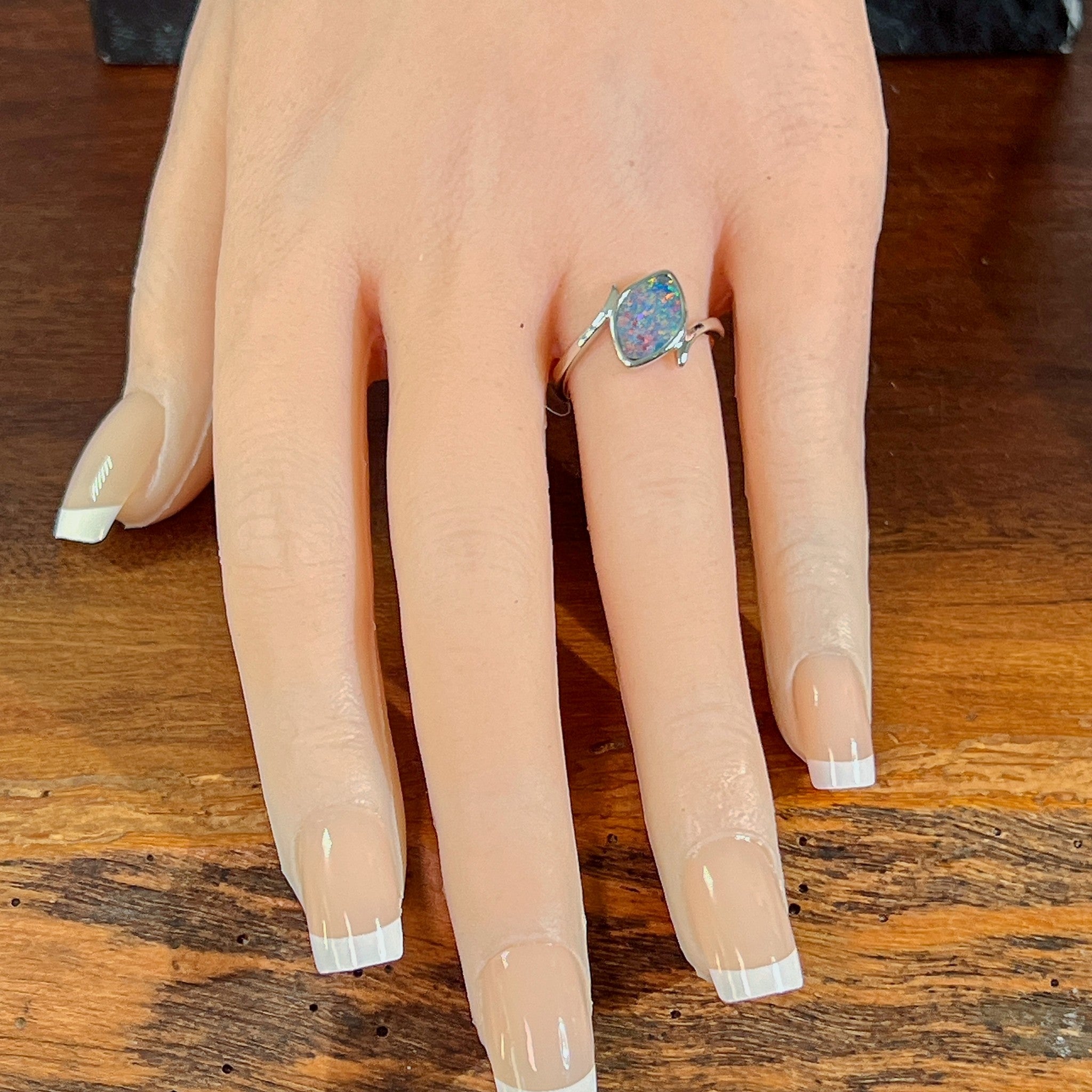 Marquise opal doublet ring in silver worn on the hand, full view across the fingers