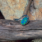 Sterling silver opal doublet bypass ring viewed from the side, showing the sweeping shank