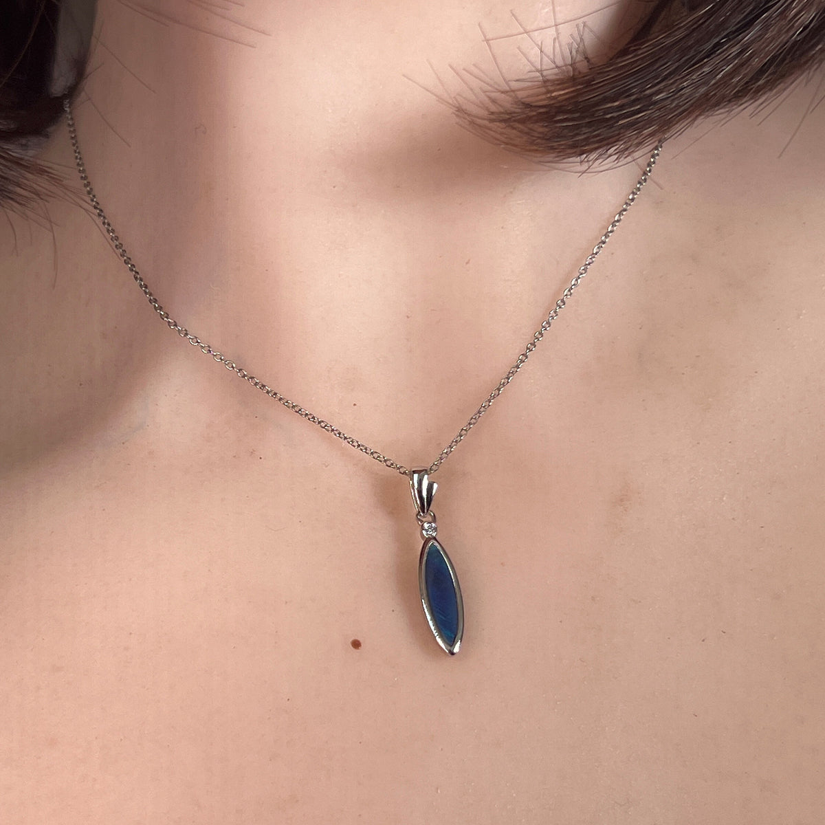 Australian opal doublet pendant worn at the neck, sterling silver, 16 x 5mm oval stone