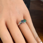 Horizontal oval opal doublet ring in silver worn on the hand, showing its scale on the finger