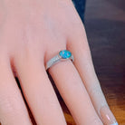Oval opal doublet ring on a pave silver band worn on the hand, showing its scale on the finger