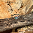 Oval opal doublet ring in silver on driftwood against Australian sandstone