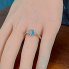 Oval opal doublet ring in silver worn on the hand, showing its scale on the finger