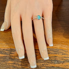 Oval opal doublet ring in silver worn on the hand, full view across the fingers