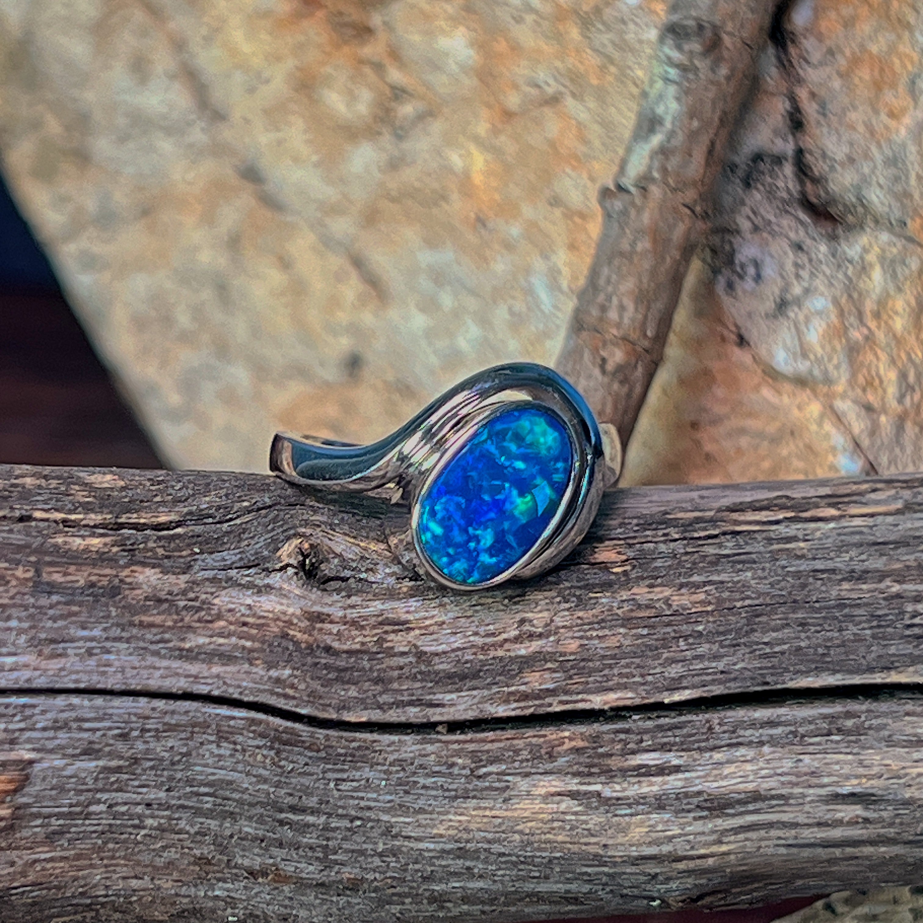 Oval opal doublet ring in silver viewed from the side, showing the curved shank