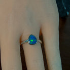 Pear-shaped opal doublet ring worn on the hand, showing its scale on the finger