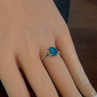 Bezel-set opal doublet ring in sterling silver worn on the hand, side view