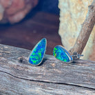 Teardrop opal doublet stud earrings in silver against a dark background, showing green flash