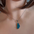 Green and blue opal doublet pendant in silver worn on a fine chain at the neckline