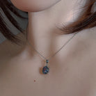 Sterling silver opal triplet pendant worn at the neck, showing its scale on the collarbone