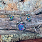 Sterling silver heart opal triplet jewellery set arranged on driftwood