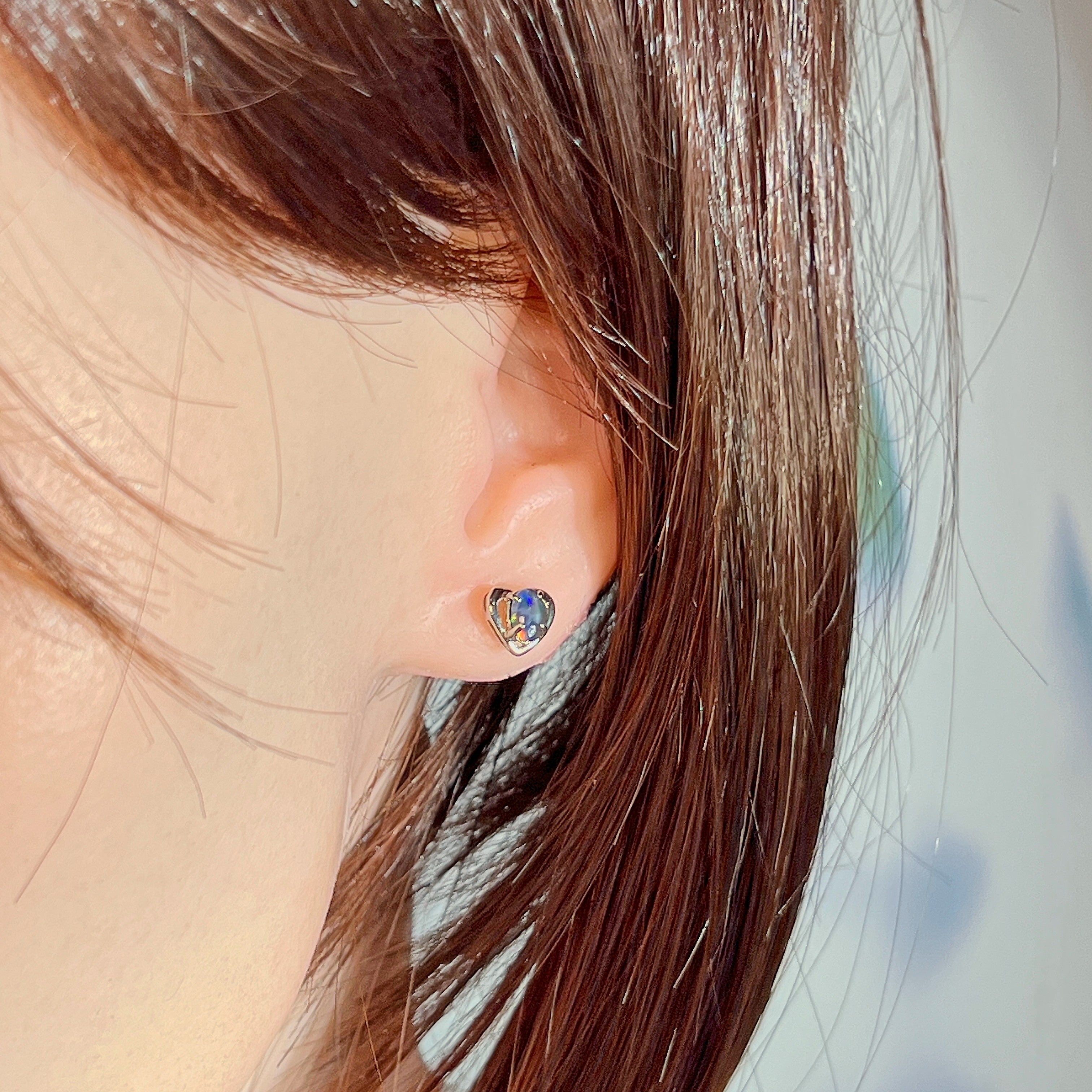 Silver heart opal triplet earring worn on the ear, side profile view