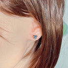 Opal triplet heart stud worn on the ear beneath loose hair