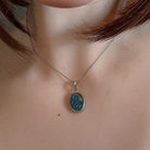 Oval opal triplet necklace in silver worn at the neck on a fine chain