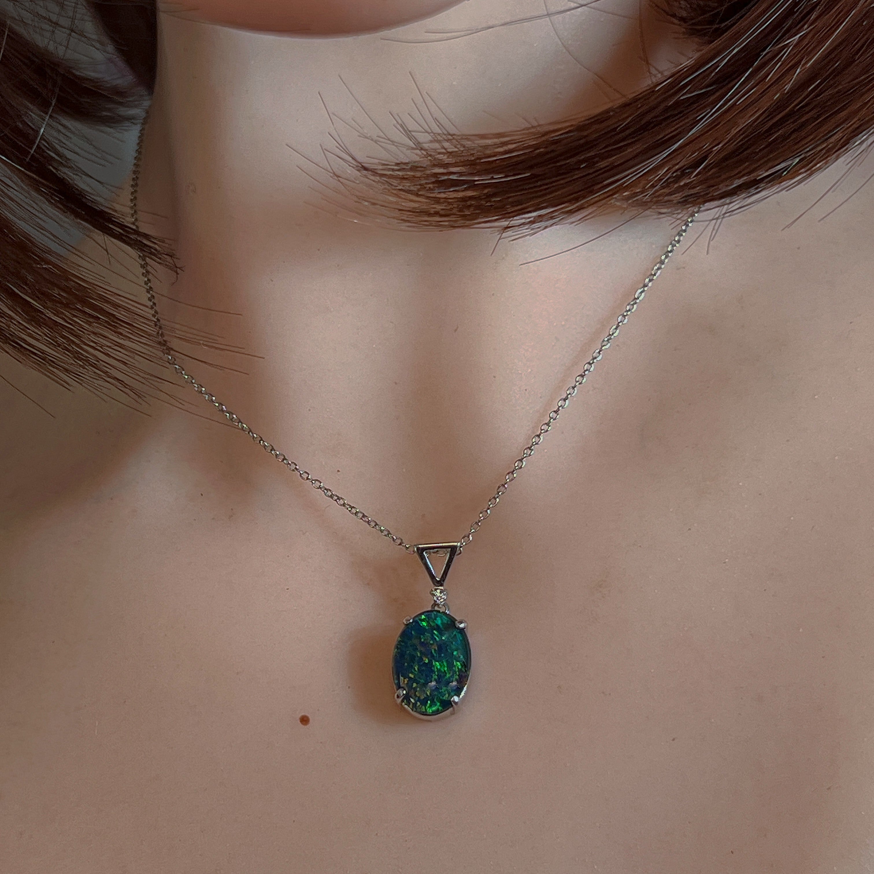 Claw-set opal triplet pendant worn at the neck, showing its scale on the collarbone
