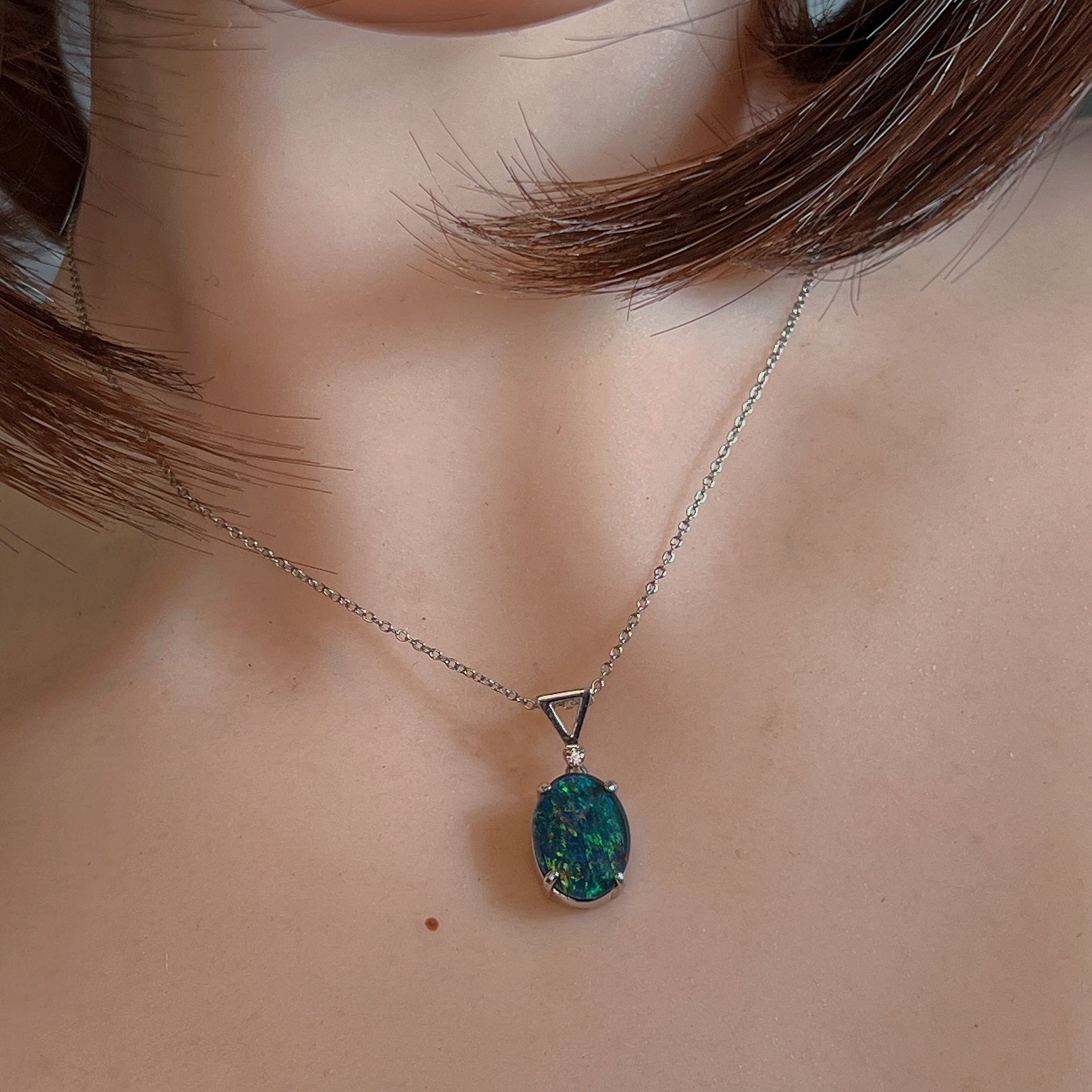 Opal triplet pendant worn at the neck, close view of the claw setting