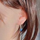 Worn close-up of the 8x6mm oval opal triplet earring in sterling silver