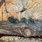 Close view of the red, orange, yellow and green play of colour in the freeform opal triplet