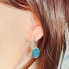oval Australian opal triplet earrings in sterling silver, worn on the ear