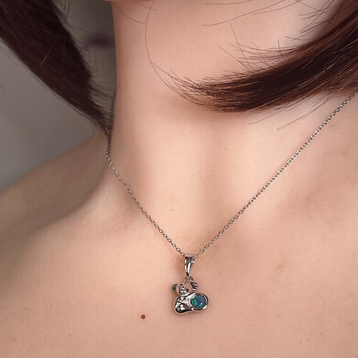 5mm round Australian opal triplet pendant worn at the neck, sterling silver