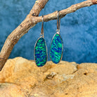 White gold opal doublet drop earrings in close view, green and blue flash across the stones