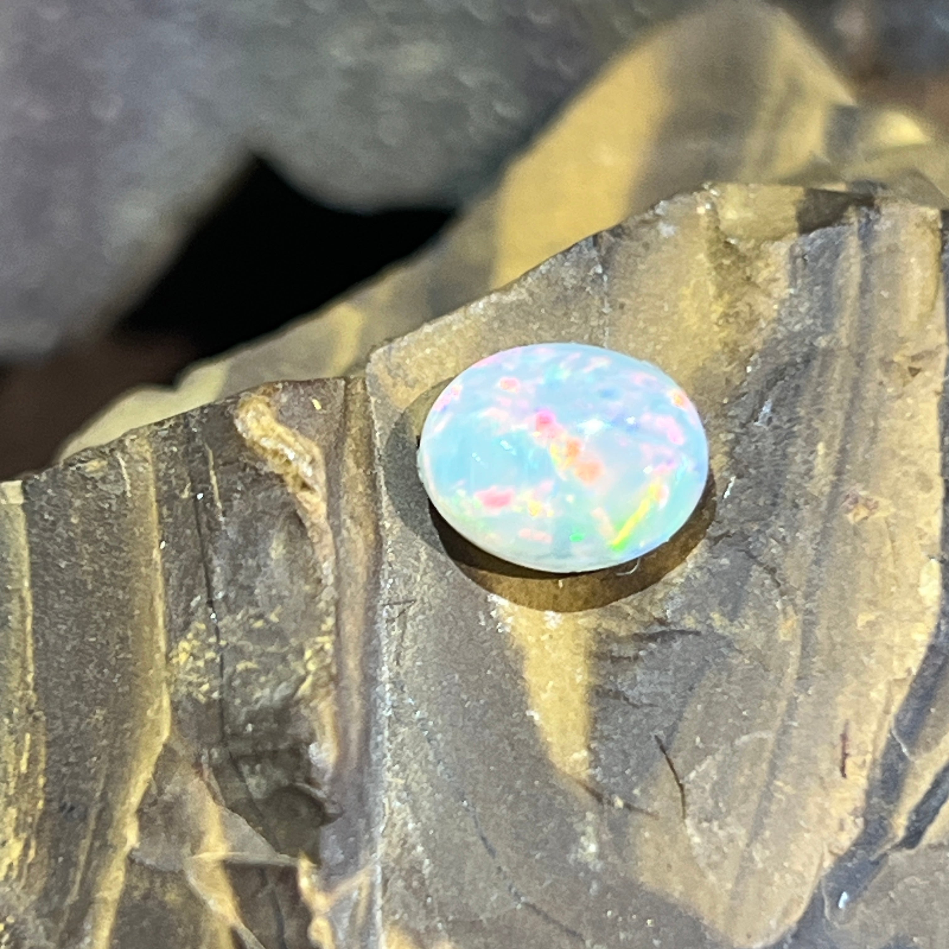 1.3ct Australian white opal close up, dense pink, red and green pinfire across the face
