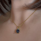 Oval opal triplet pendant worn at the neck, showing its scale on the collarbone