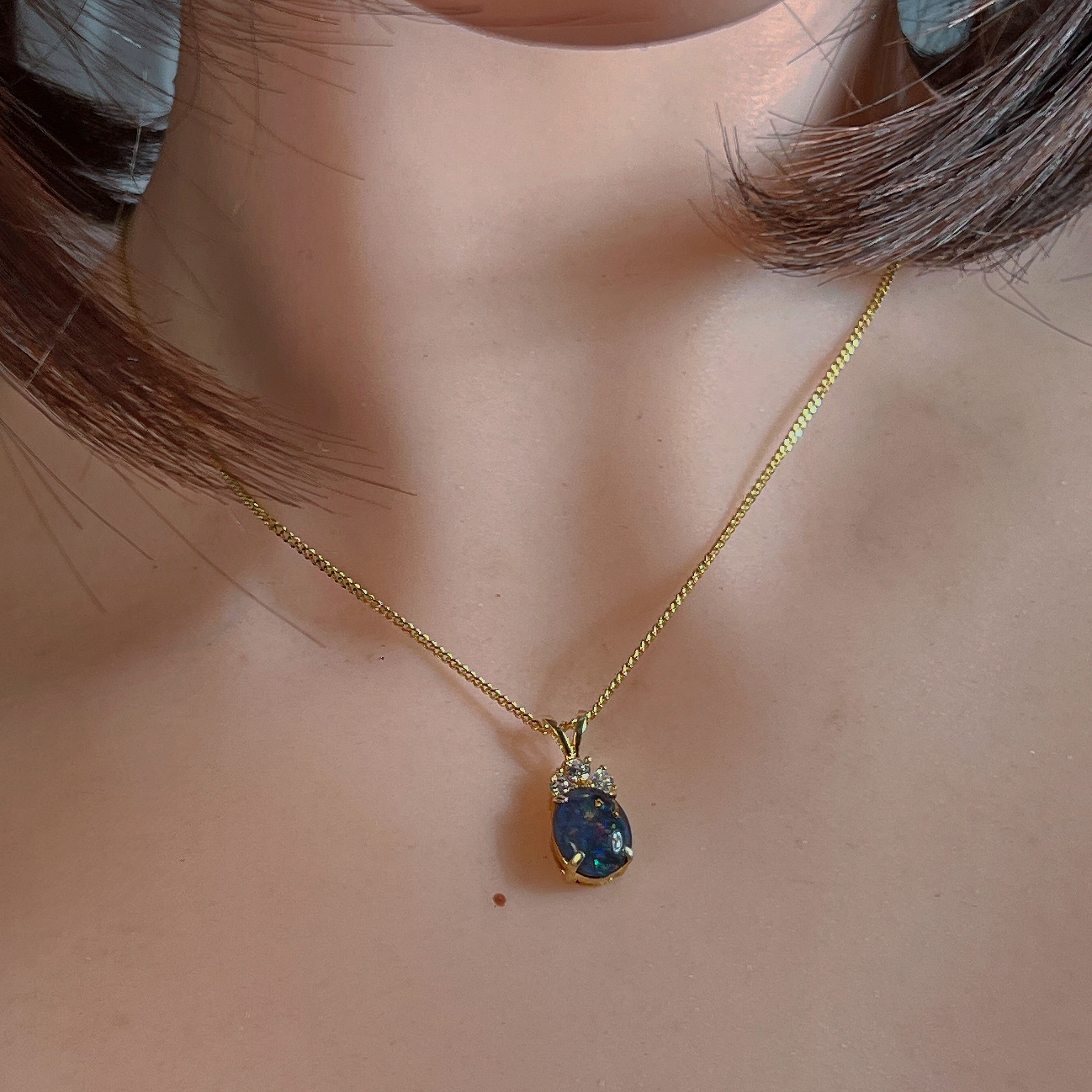 Gold-plated silver opal triplet pendant worn at the neckline, close view