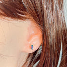 6x4mm opal triplet stud earring worn on the ear, showing its scale on the earlobe
