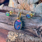 Bezel-set opal triplet jewellery set in yellow gold-plated silver, close view on driftwood