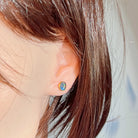 Opal triplet stud in gold-plated silver worn on the ear, side profile view