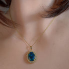 Opal triplet halo pendant worn at the neck on a fine gold-plated chain