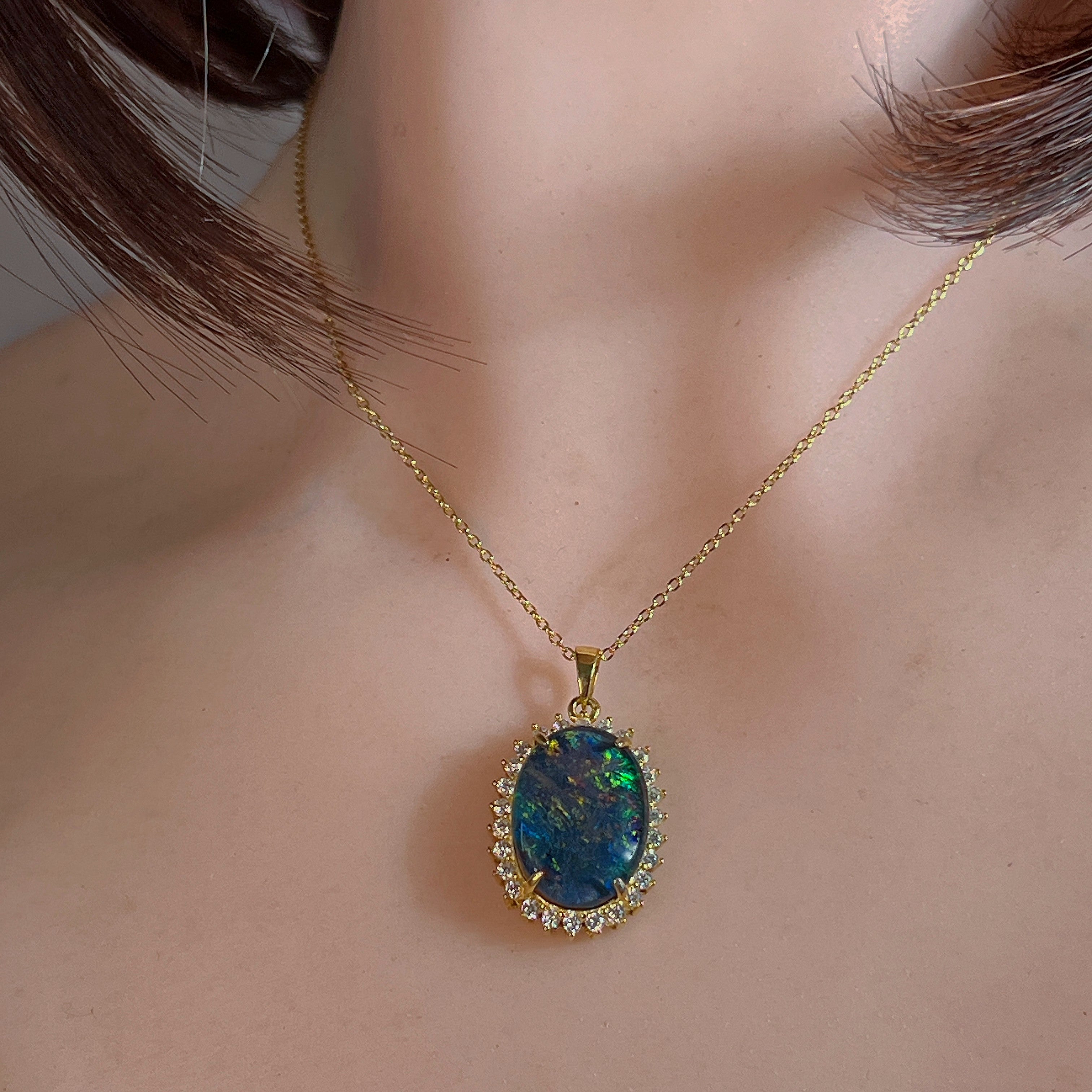 18x13mm opal triplet halo pendant worn at the neck on a gold-plated chain
