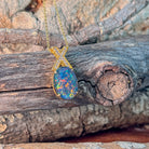 Oval opal triplet pendant showing red, blue and green play-of-colour on a gold-plated chain