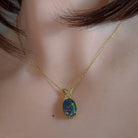 Opal triplet pendant worn at the neck, showing its scale on the collarbone