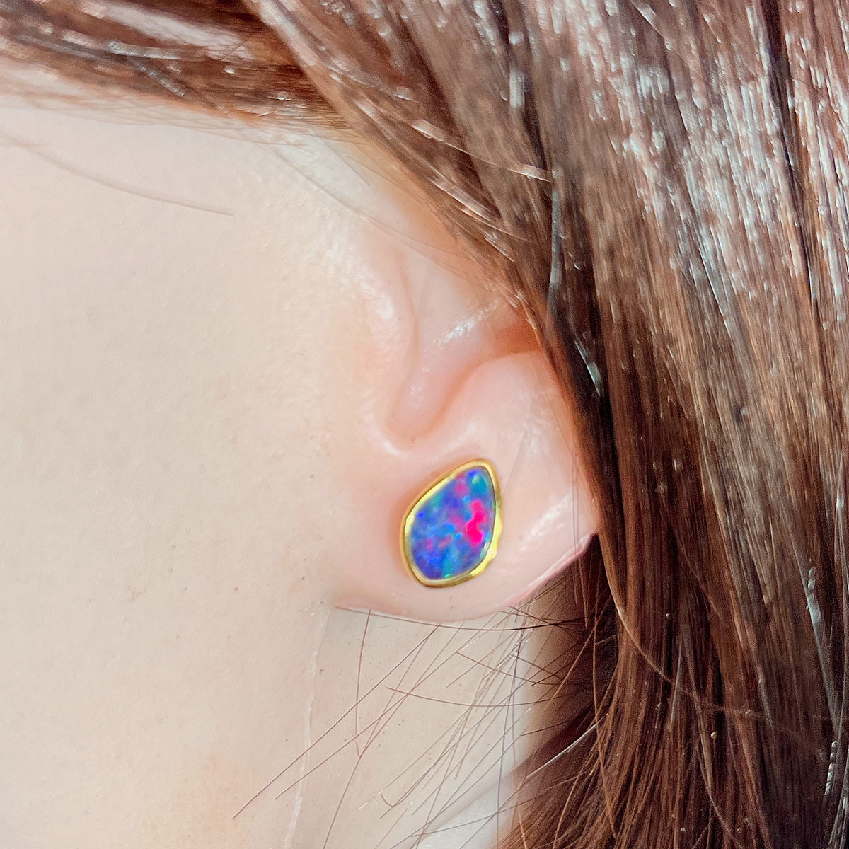 Worn Australian opal doublet earrings in yellow gold-plated silver, red, blue and green, 11 x 7.5mm