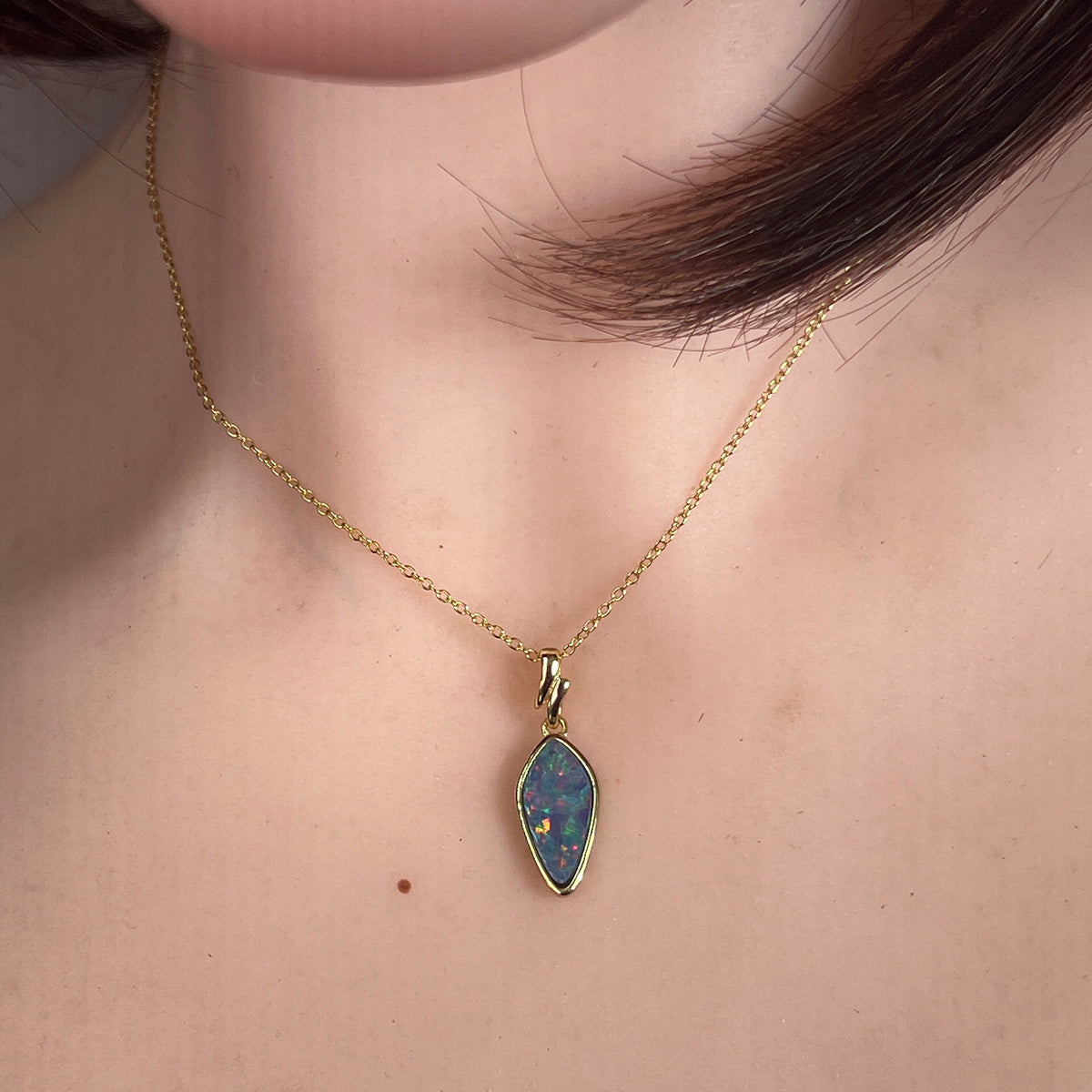 Worn Australian opal doublet pendant in yellow gold-plated silver, red, blue and green, 16 x 8mm