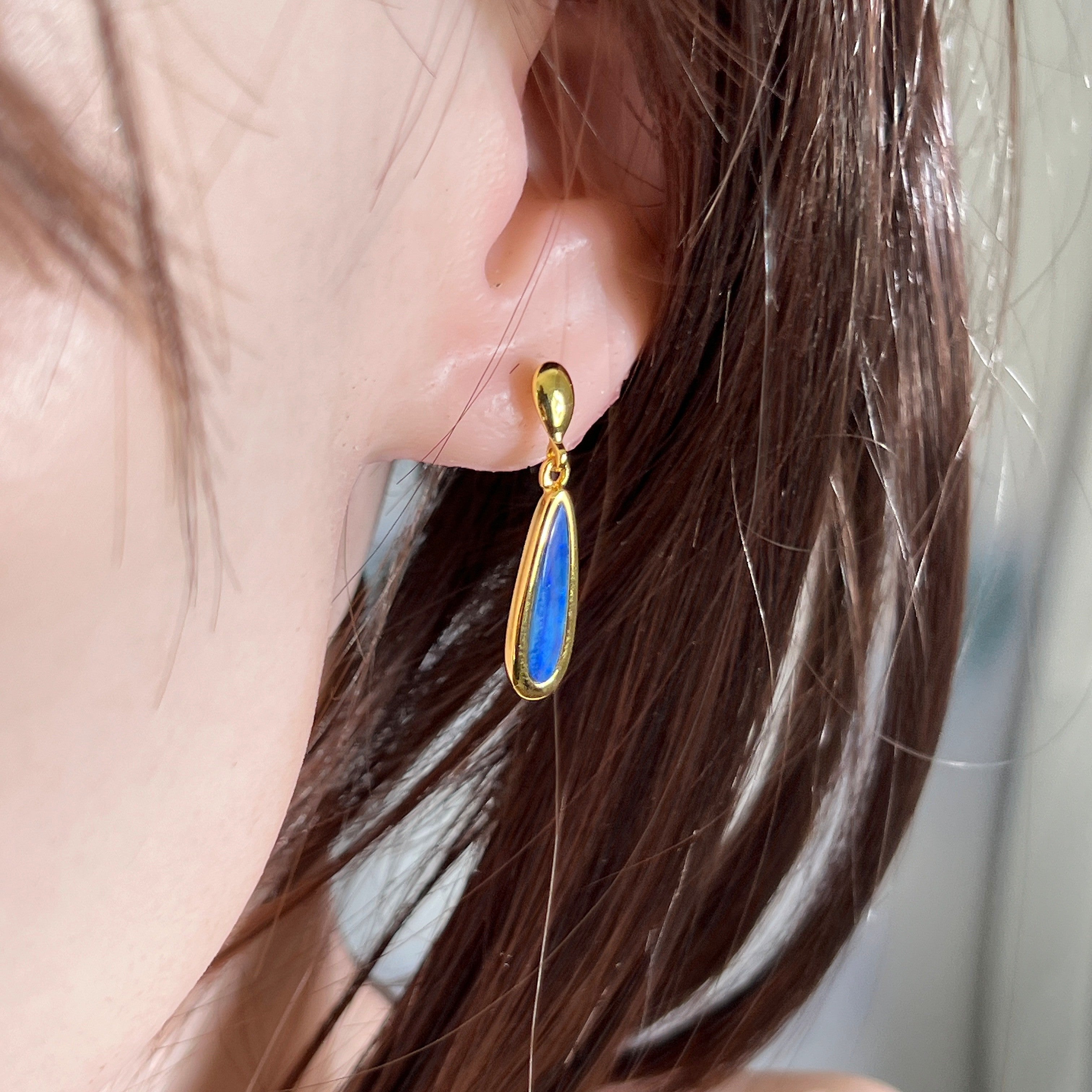 17 x 5mm pear-shaped Australian opal doublet earrings worn on the ear, yellow gold-plated silver