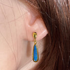 Worn Australian opal doublet earrings in yellow gold-plated silver, green and blue, 17 x 5mm