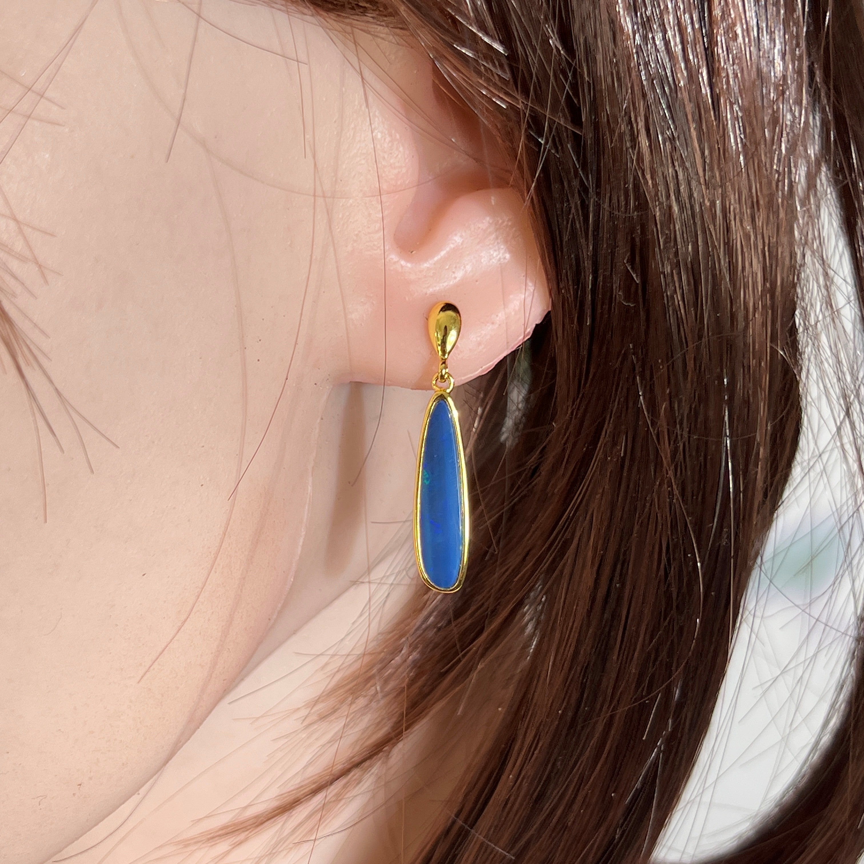 22 x 5.5mm pear-shaped Australian opal doublet earrings worn on the ear, yellow gold-plated silver