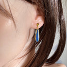 Worn Australian opal doublet earrings in yellow gold-plated silver, green and blue, 22 x 5.5mm