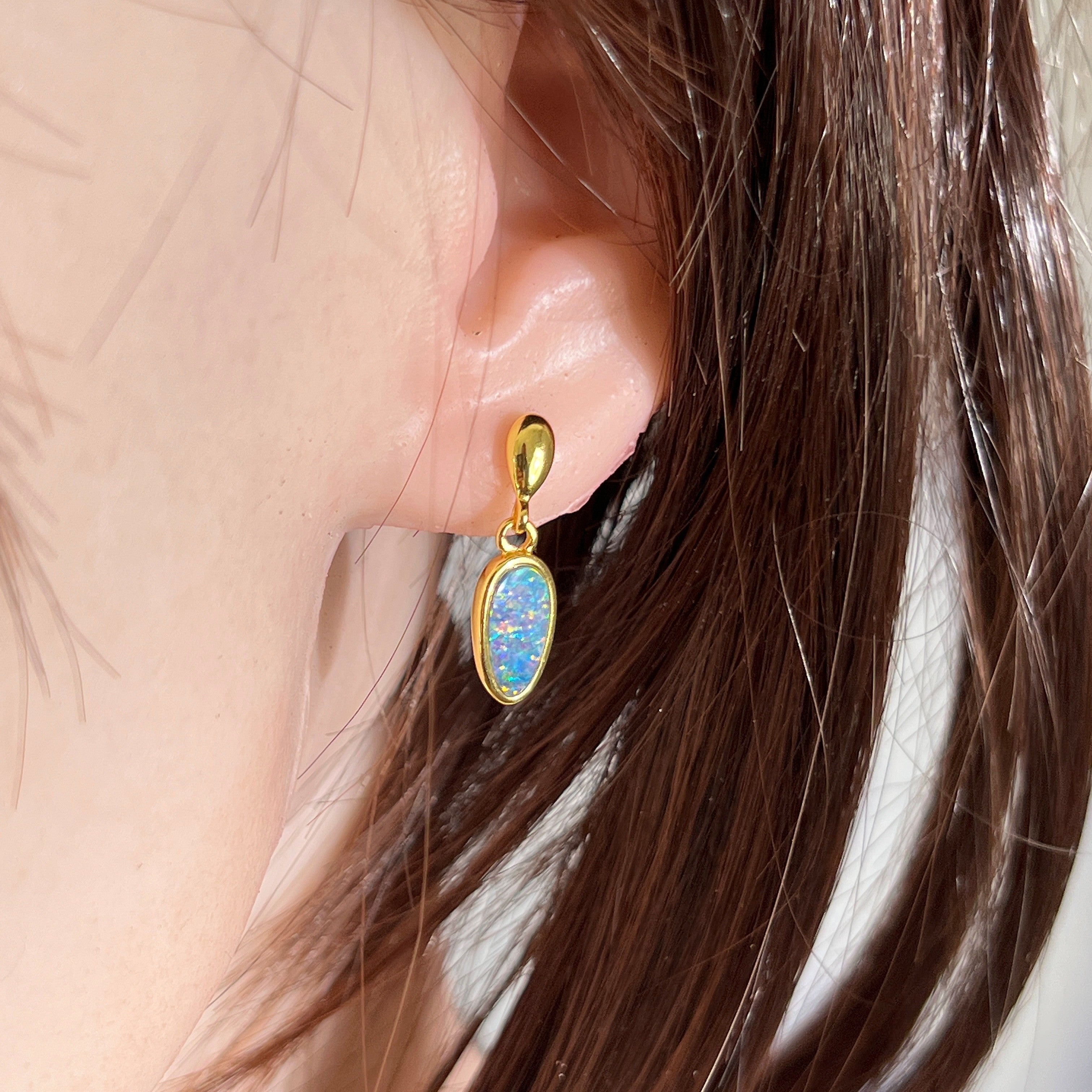 Australian opal doublet earrings worn on the ear, red, pink, blue and green play-of-colour