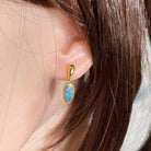 Worn Australian opal doublet earrings in yellow gold-plated silver, red, pink, blue and green, 11 x 6mm