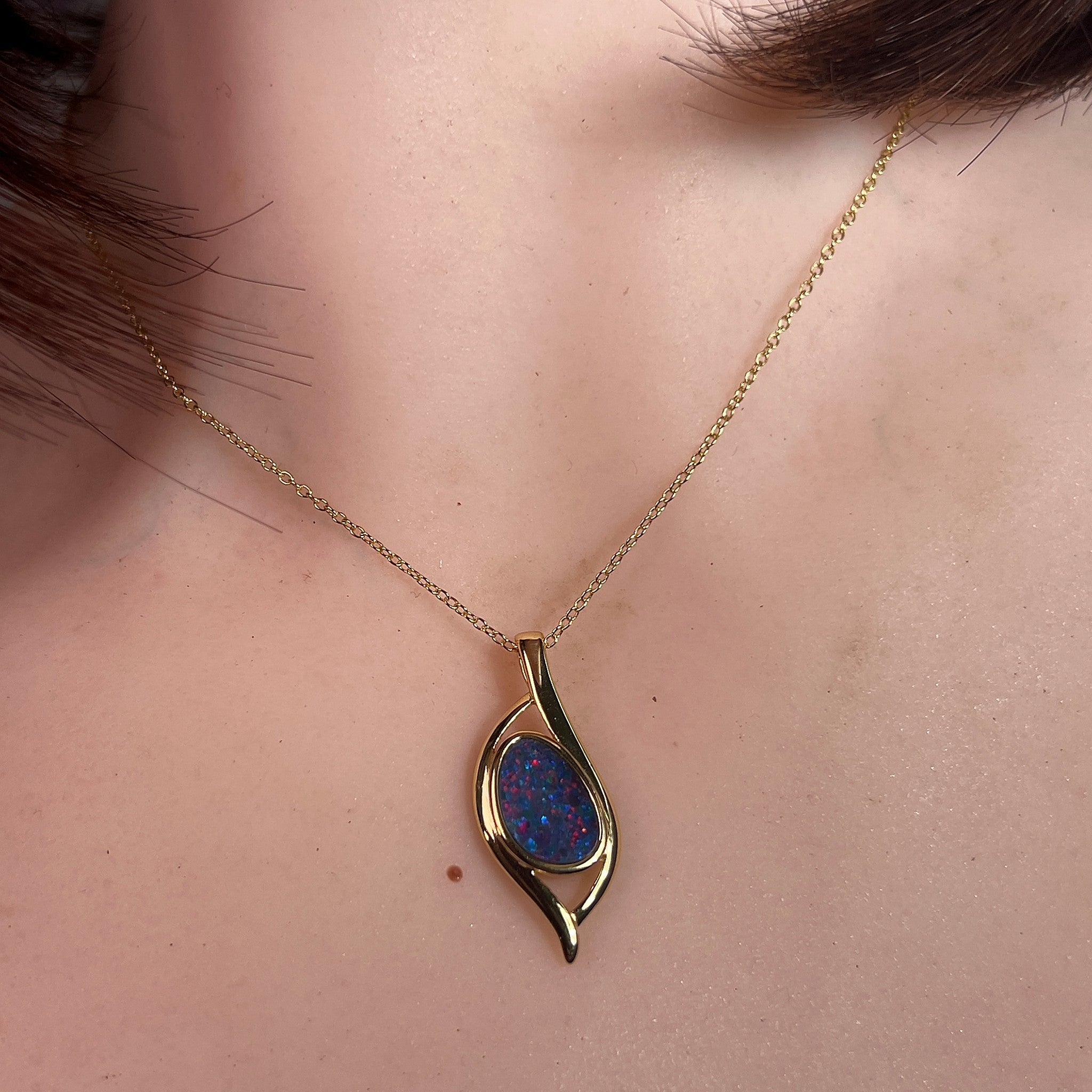 Australian opal doublet pendant worn at the neck, red and blue play-of-colour