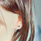 5mm round Australian opal doublet earrings worn on the ear, yellow gold-plated silver