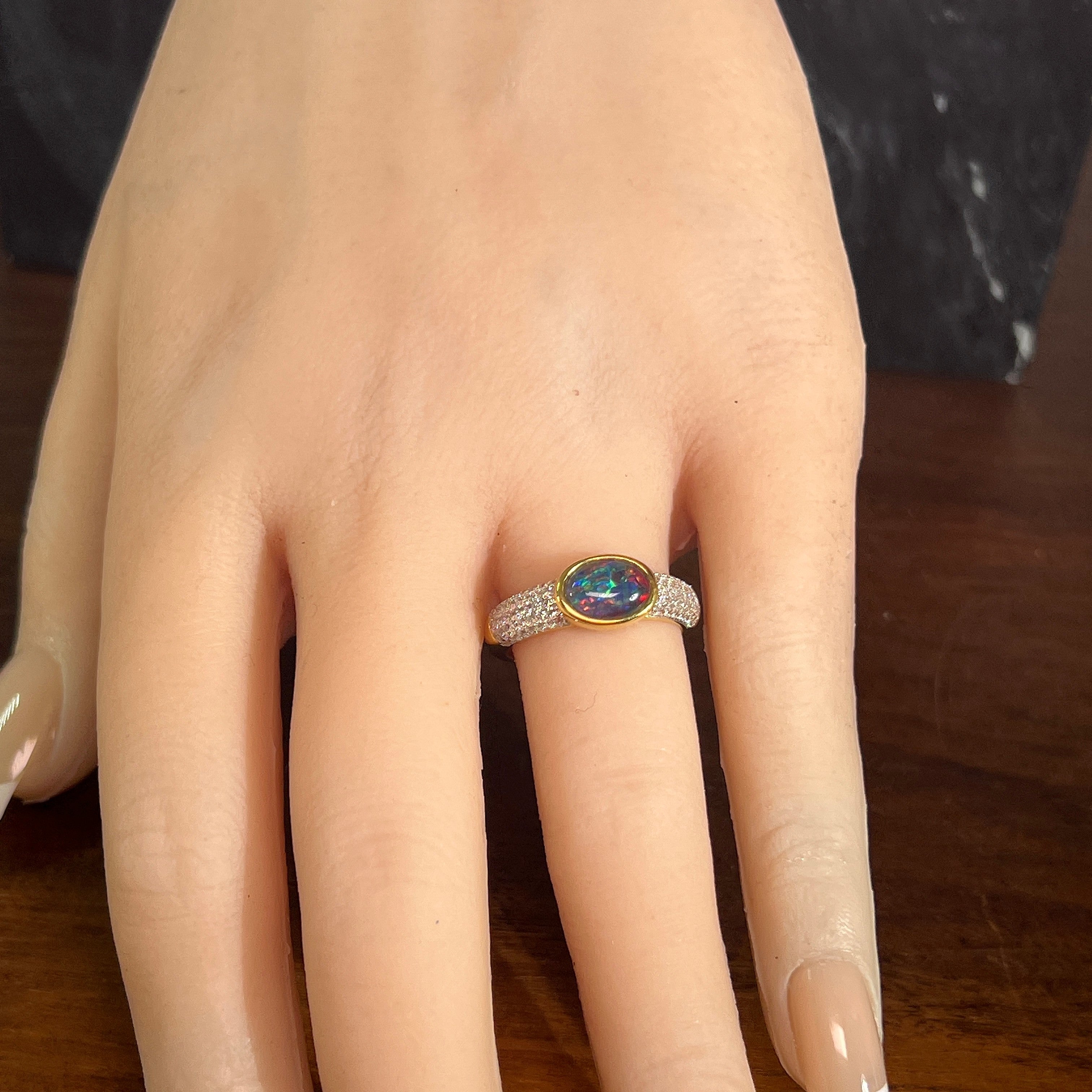 oval Australian opal triplet ring in yellow gold-plated silver, worn on the hand